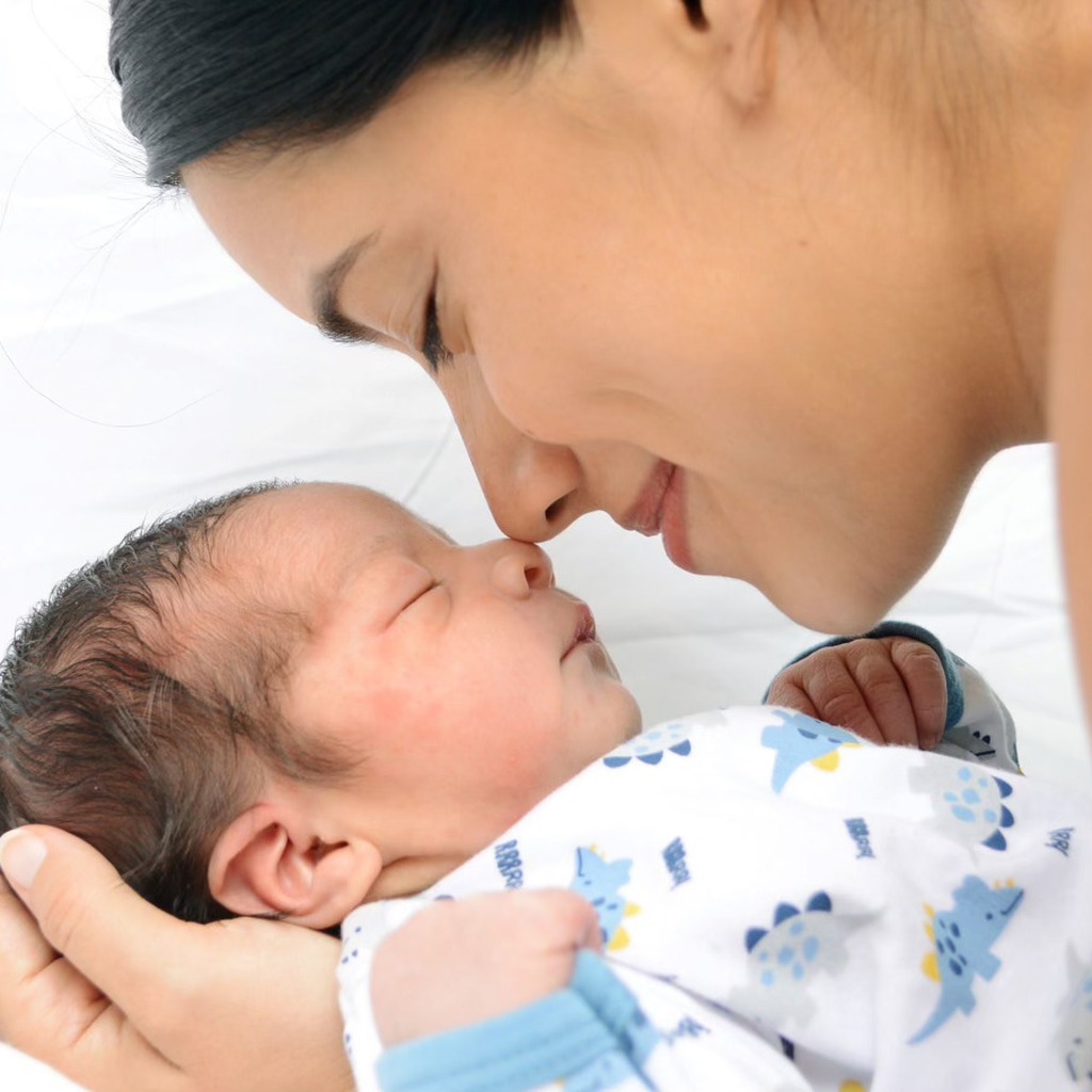 Karla, fundadora de The Mom Reviewer, besando a su bebé recién nacido